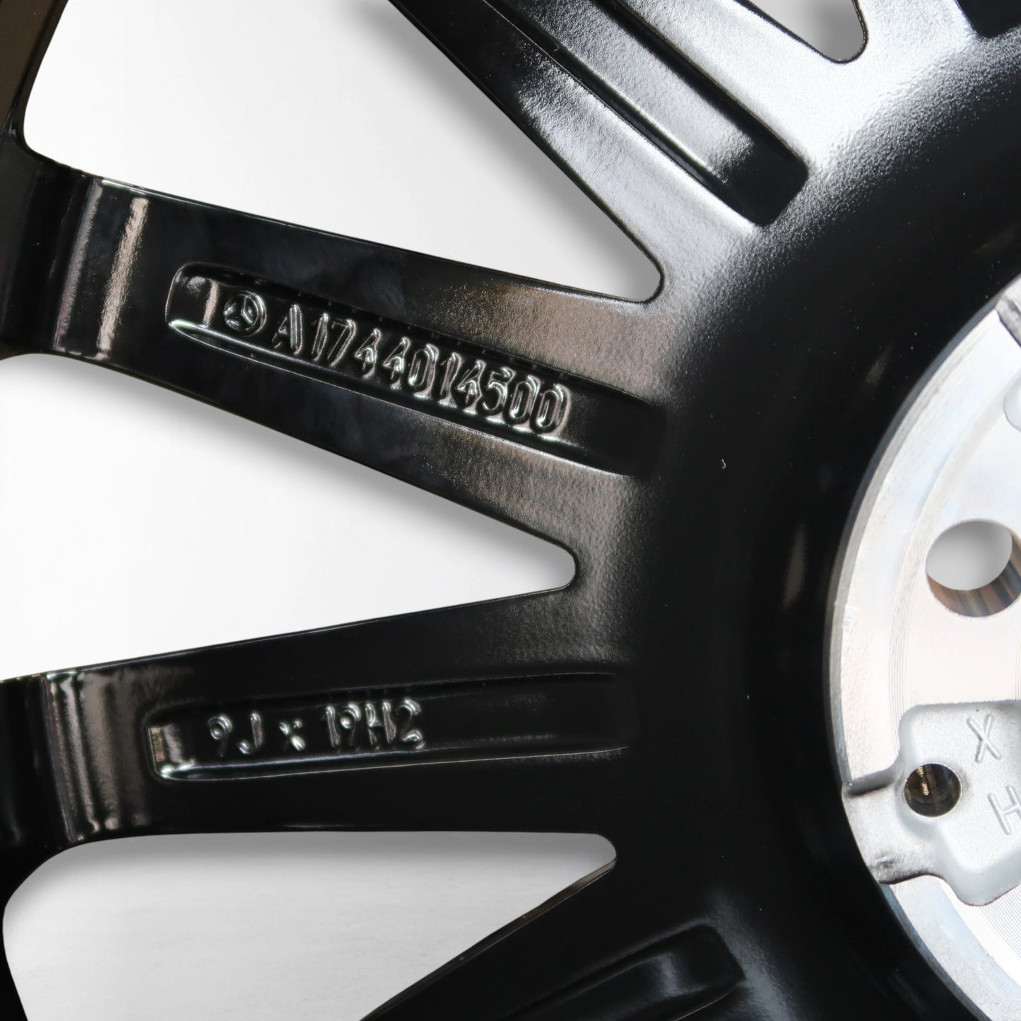 Velgdetail met gegraveerde code A1744014500 op zwarte spaak