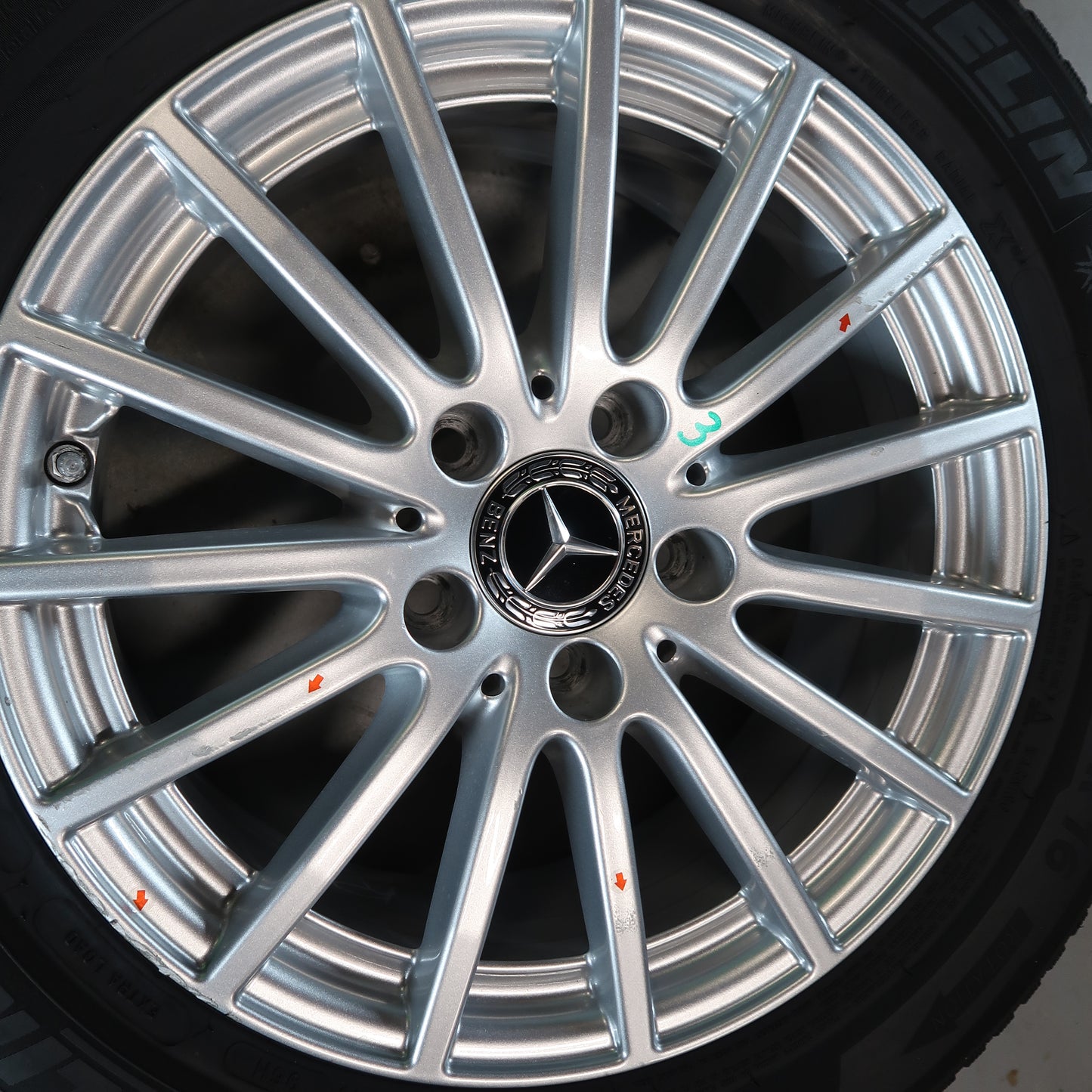 Mercedes velg close-up met zilveren spaken en naafdop-logo op band