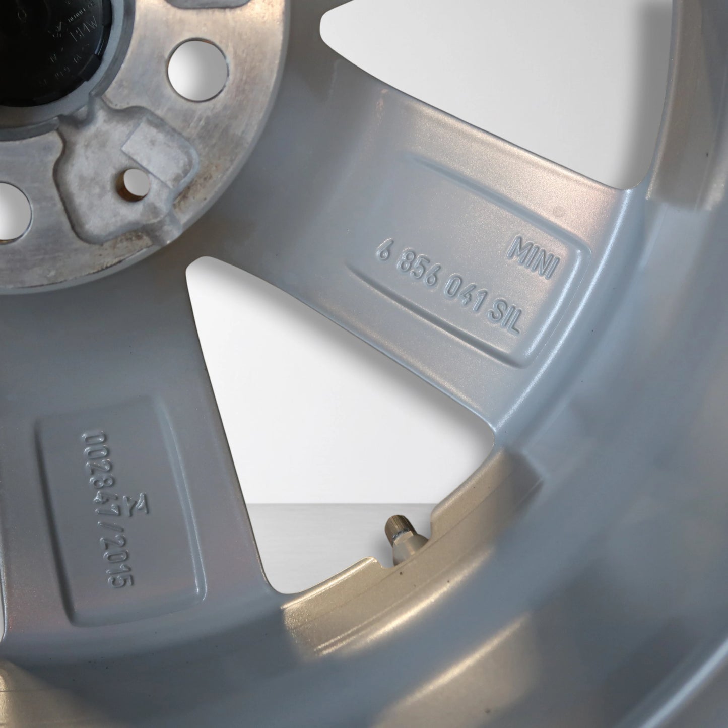 Close-up van zilveren velg met MINI en nummer 685 031 5HL op de spaak