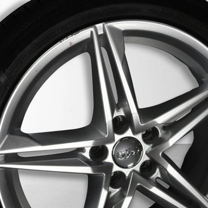 Zilveren 18-inch velg met spaken en centraal embleem