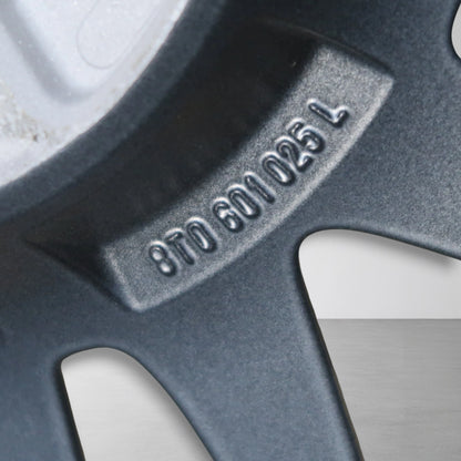 Close-up van gegraveerde velgcode op donkergrijze velg, met zichtbare tekst en puntjes.