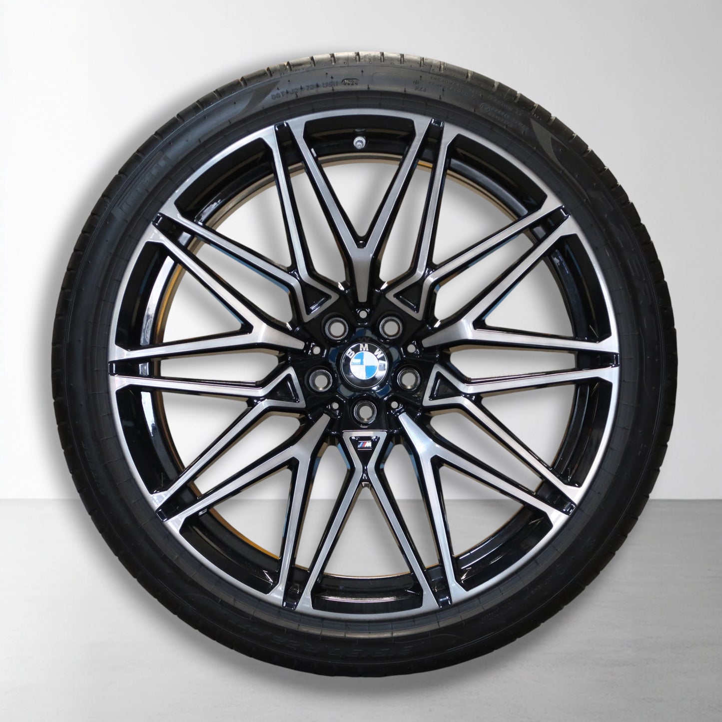 Originele lichtmetalen velg met zomerband, zwarte en zilveren spaakdesign.