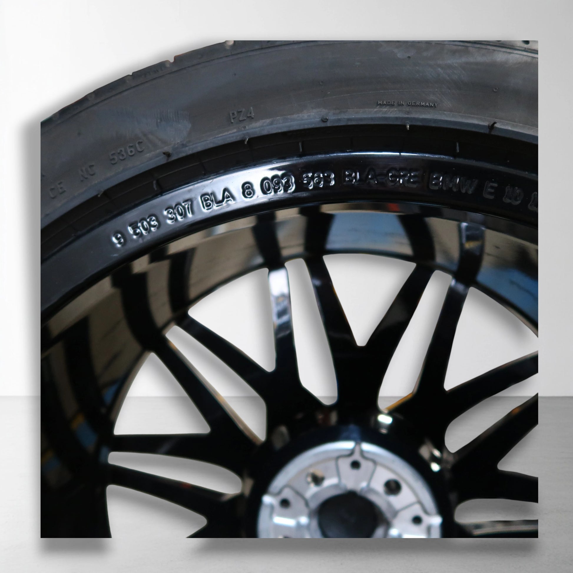 Originele lichtmetalen velg met zomerband, close-up van bandrand en zwarte spaken.