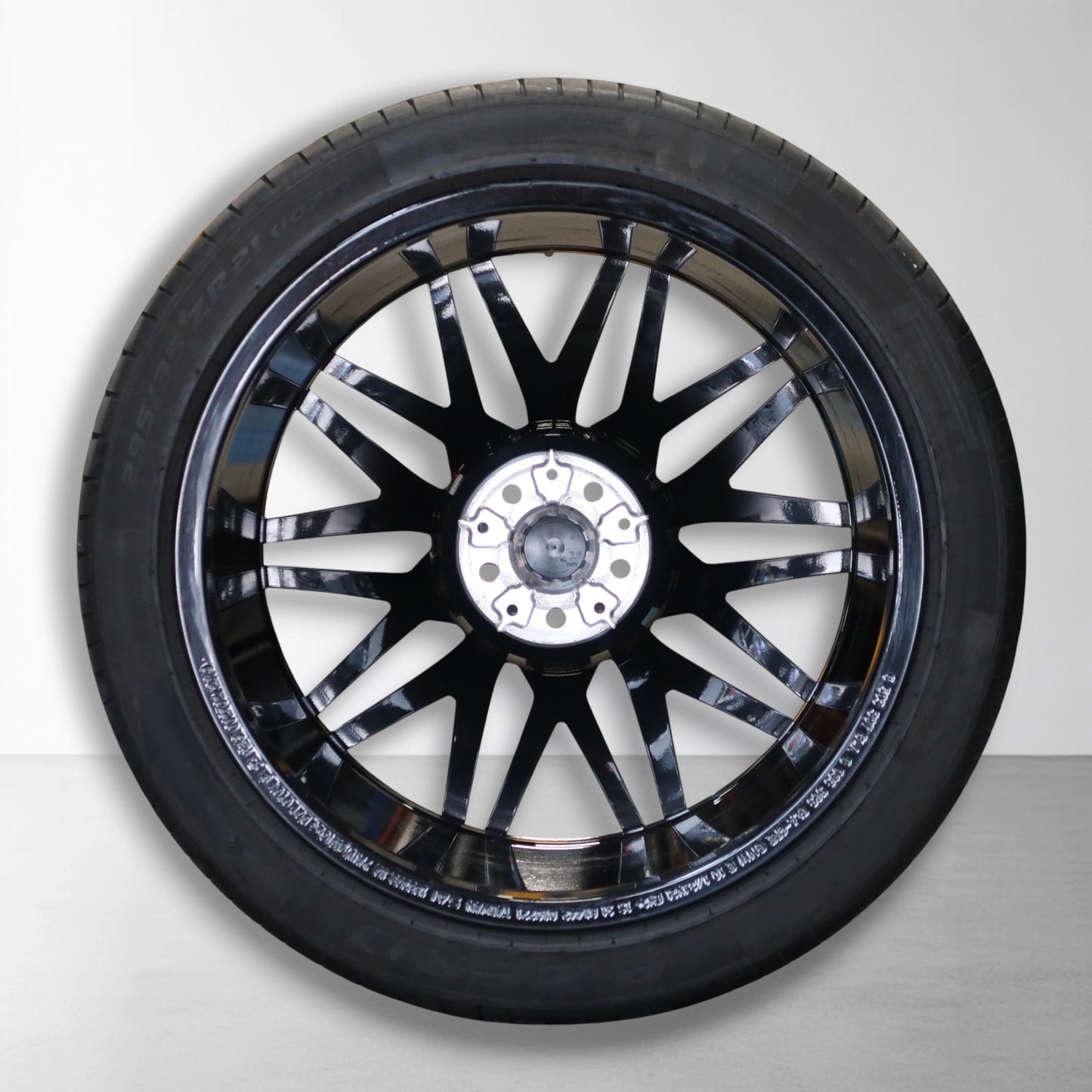 Originele lichtmetalen velg met zomerband, zilveren velgarmatuur en zwarte spaken.