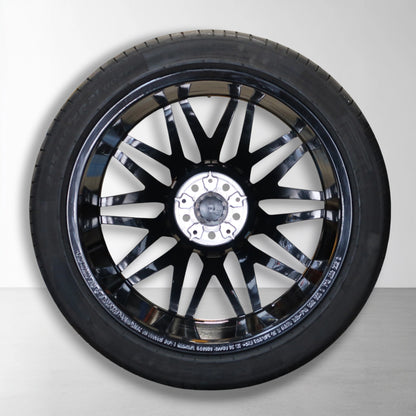 Originele lichtmetalen velg met zomerband, zilveren velgarmatuur en zwarte spaken.