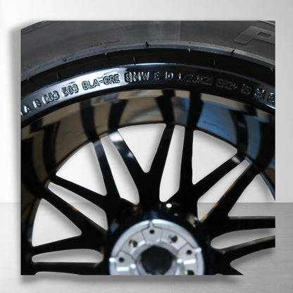 Originele lichtmetalen velg met zomerband, close-up met naaf en zwart-zilver spaken.