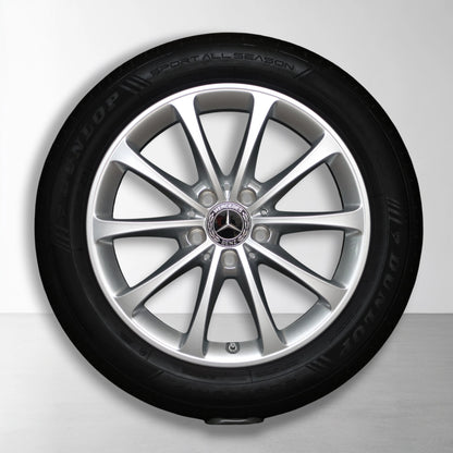 Metalen velg met all-season band, zilverkleurige spaken en Mercedes-logo in naaf
