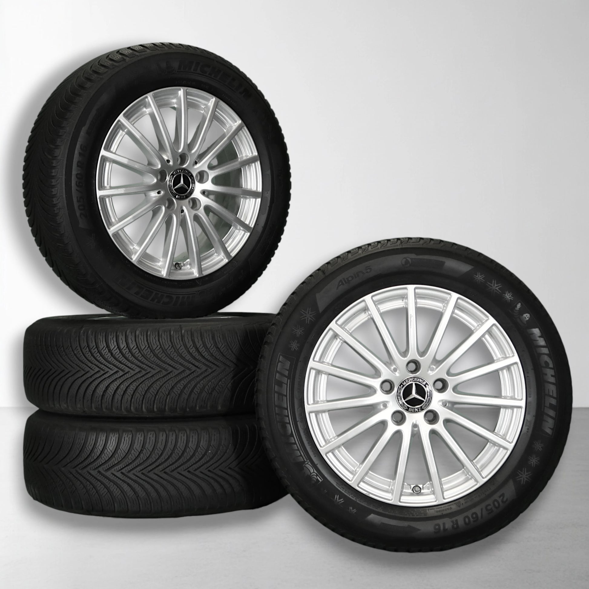 Vierwielset met twee zilveren Mercedes velgen en zwarte winterbanden