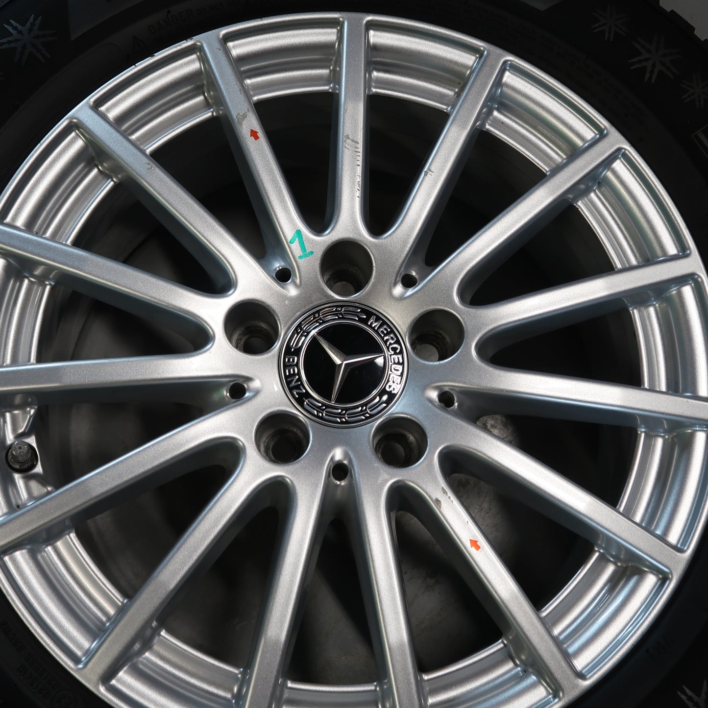 Mercedes velg close-up met spaken, naafdop en zwarte bandflank