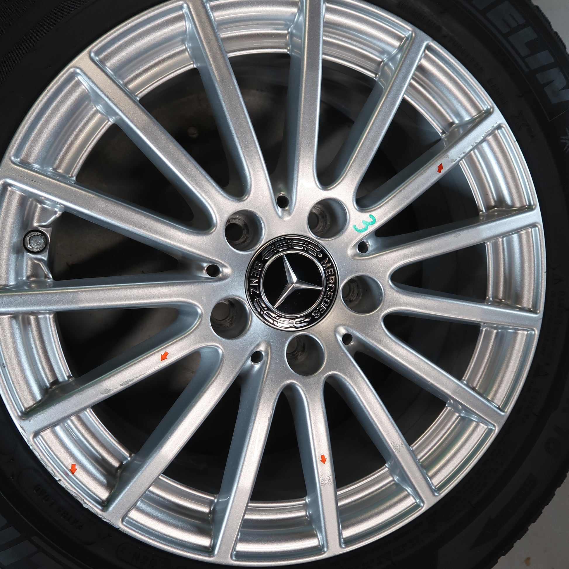 Mercedes velg close-up met zilveren spaken en naafdop-logo op band