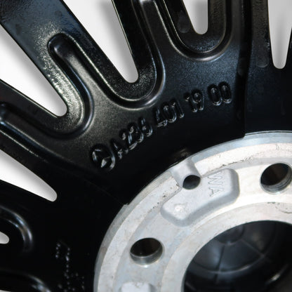 Close-up van zwarte velg met gegraveerde cijfers en boutgaten naast bandvlak