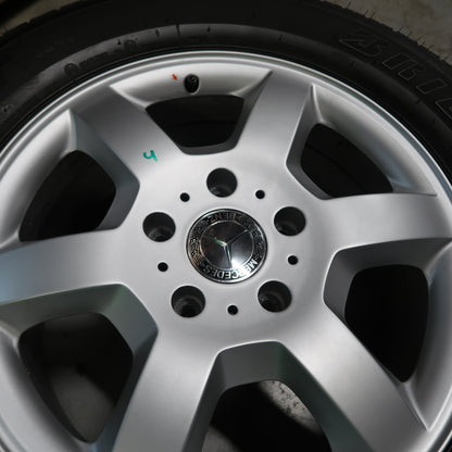 Klein detail van zilverkleurige velg met naafdop en zwarte zomerband