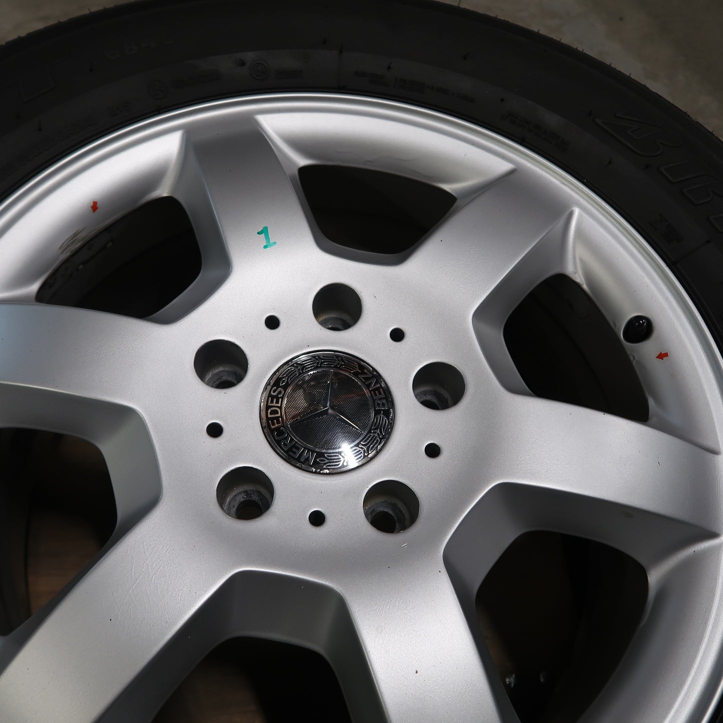 Detail van zilverkleurige naafdop met Mercedes-logo in het midden van de velg