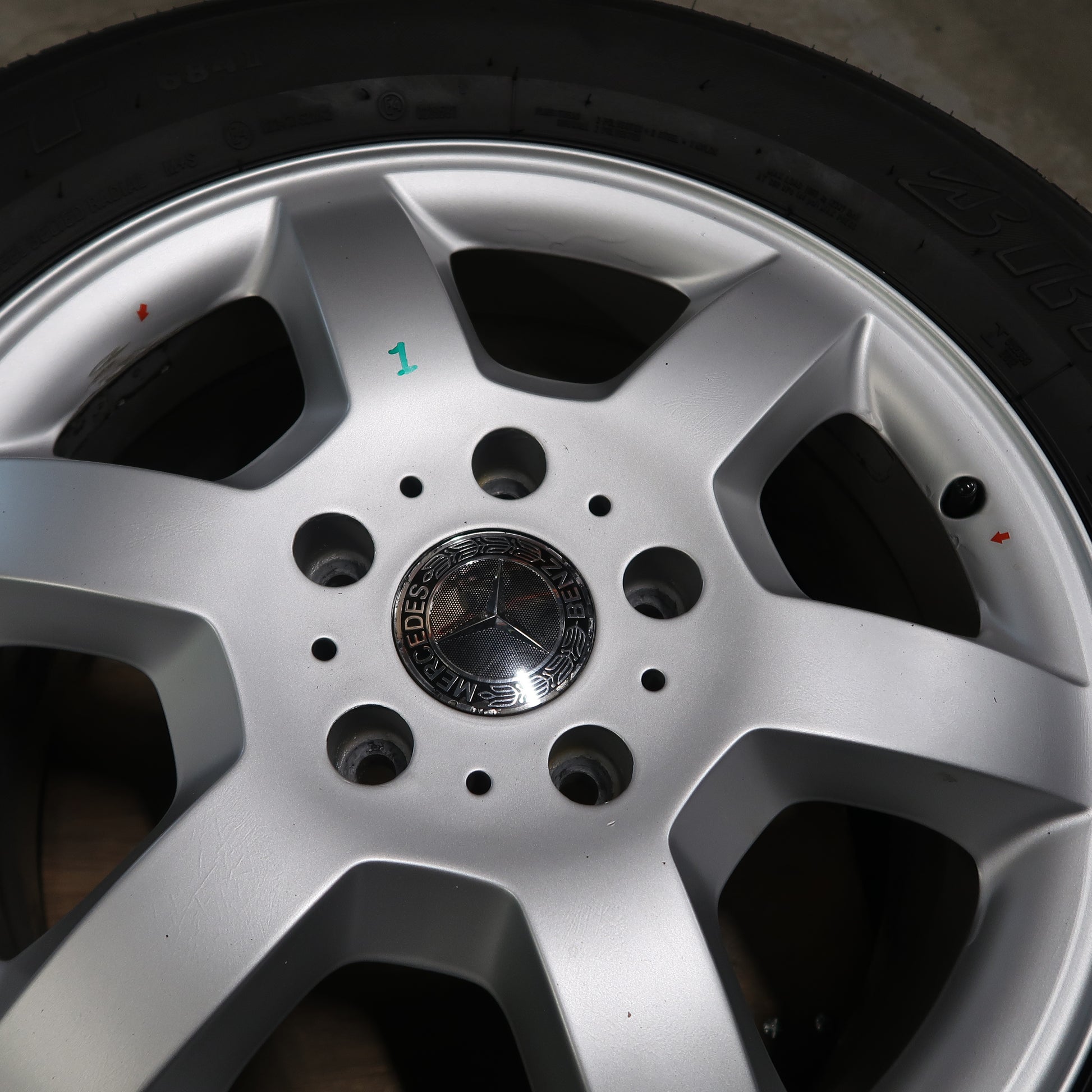 Detail van zilverkleurige naafdop met Mercedes-logo in het midden van de velg