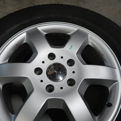 Close-up van zilverkleurige velg met naafdop en zwarte bandenrand