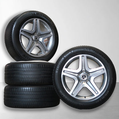 Set velgen met zwarte banden; vijf-spaaks Mercedes-ontwerp met logo in naaf