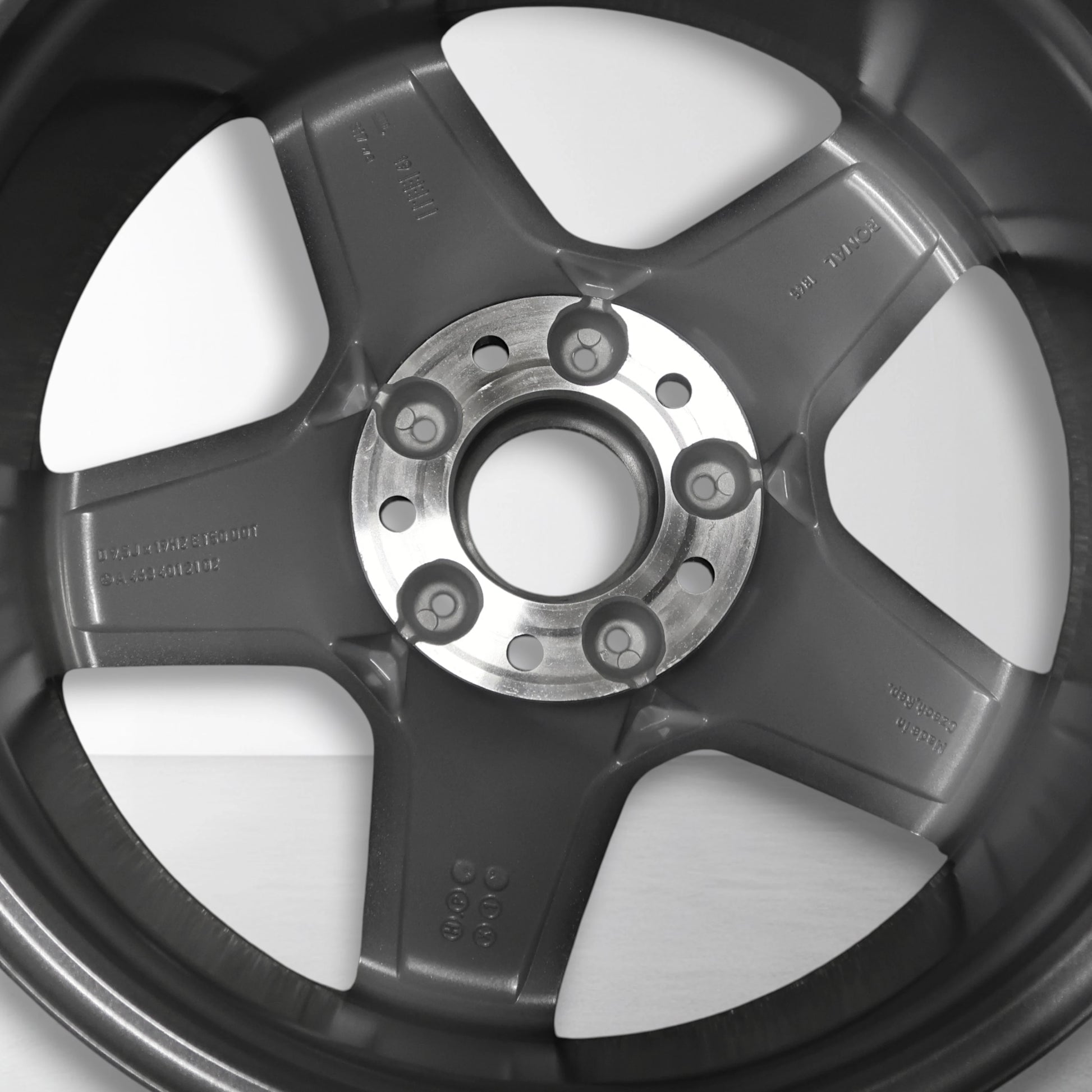 Achterzijde van lichtmetalen velg met naaf en boutgaten, grijs met zilveren spaken.
