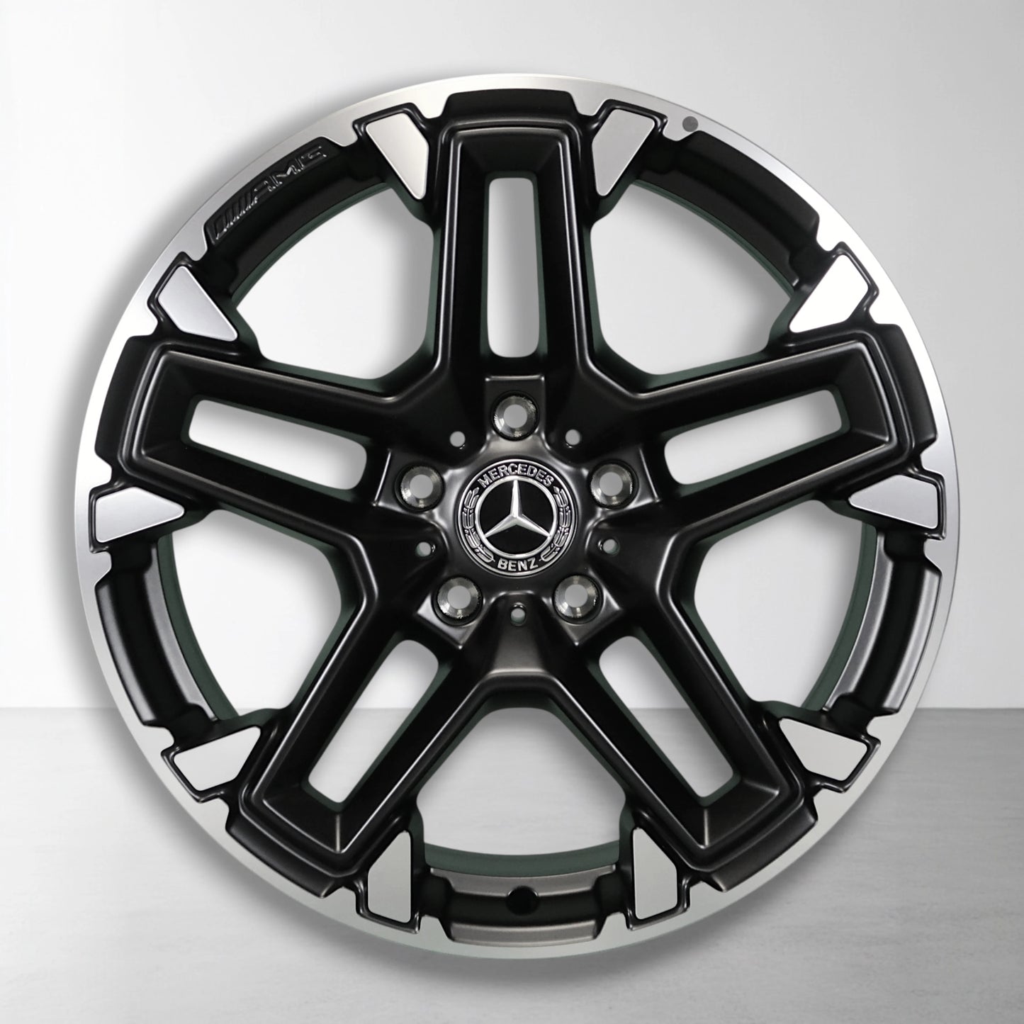 Lichtmetalen velg met zwarte en zilveren gespleten spaken, Mercedes-logo in het midden