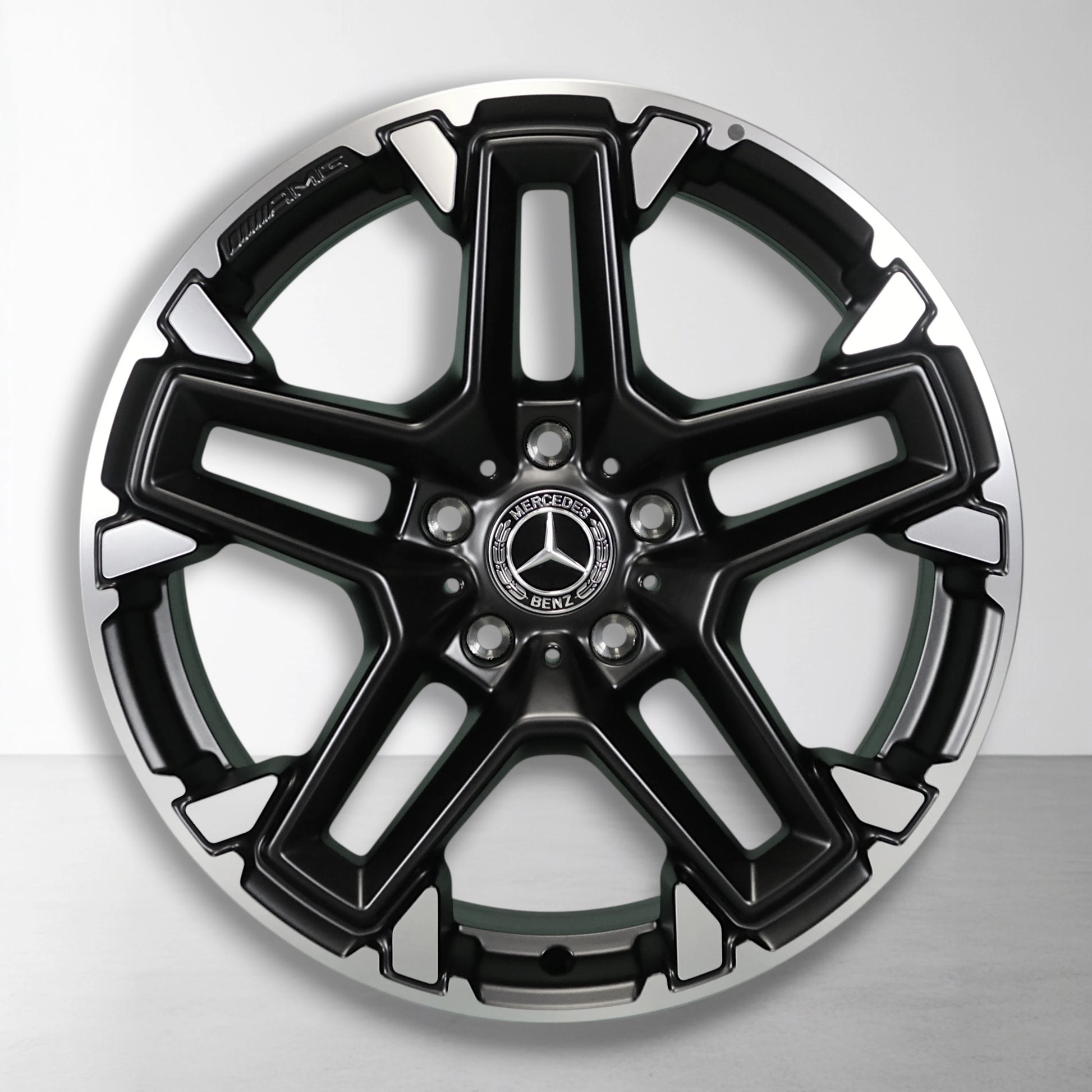 Lichtmetalen velg met zwarte en zilveren gespleten spaken, Mercedes-logo in het midden
