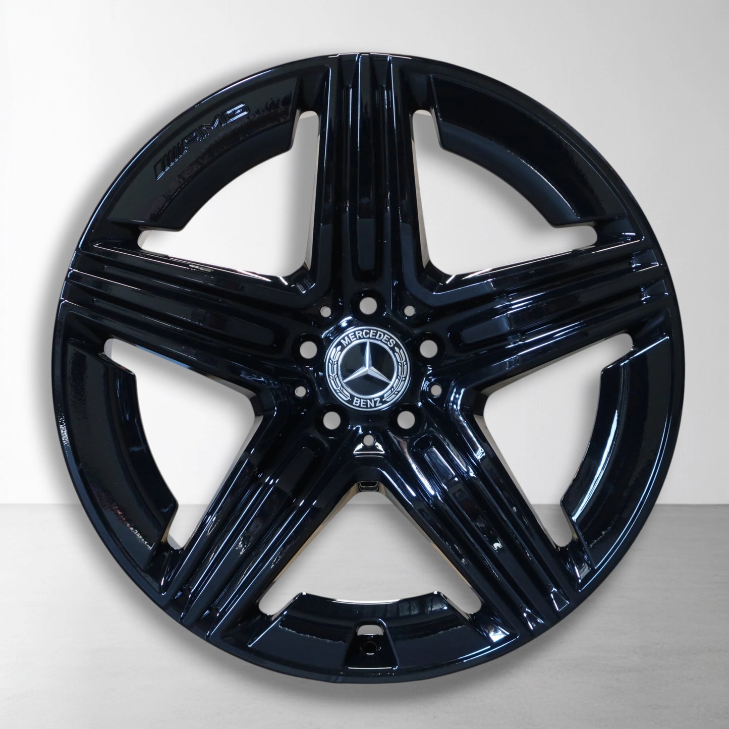 Zwarte Mercedes velg met glanzende spaken en centraal logo-embleem