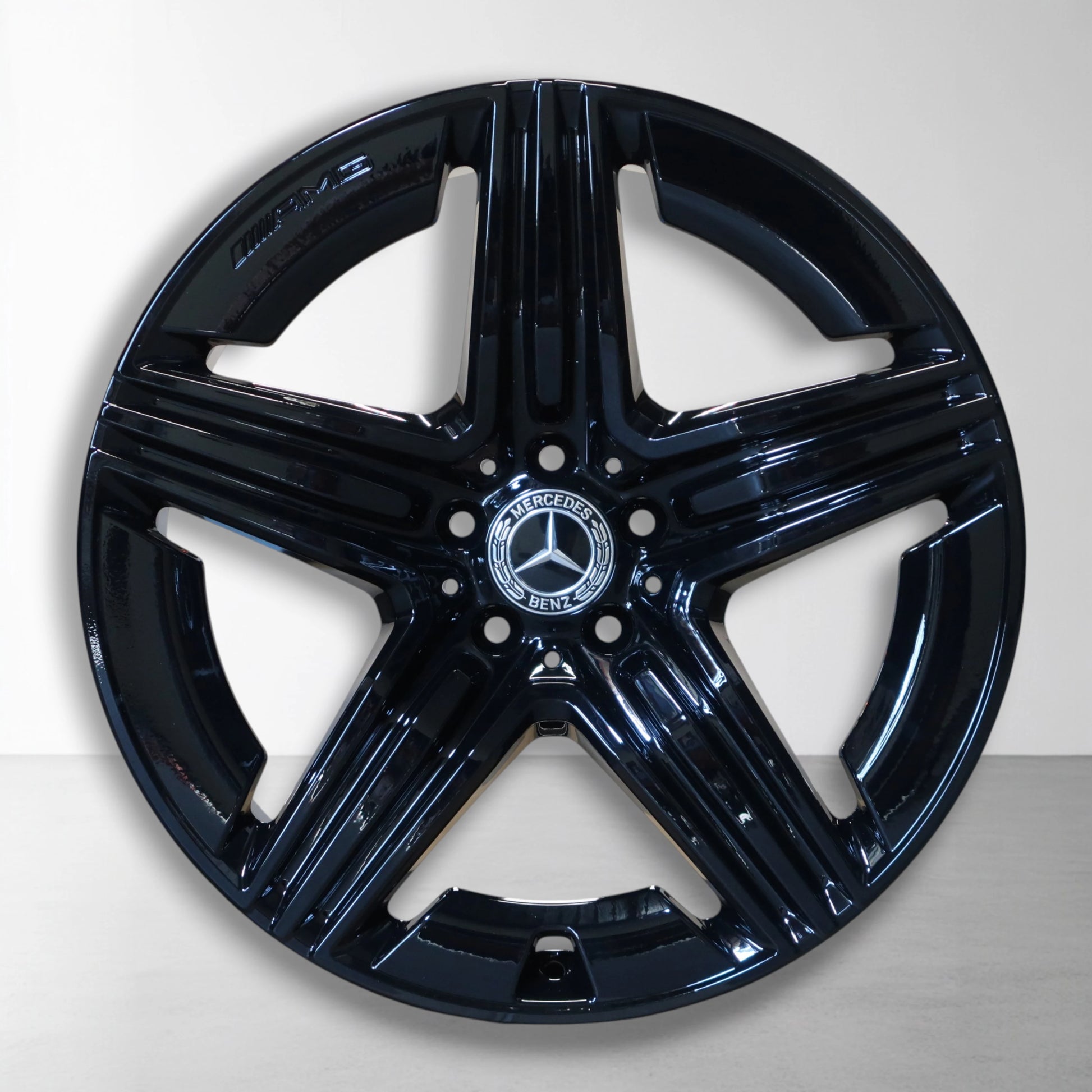 Zwarte Mercedes velg met glanzende spaken en centraal logo-embleem