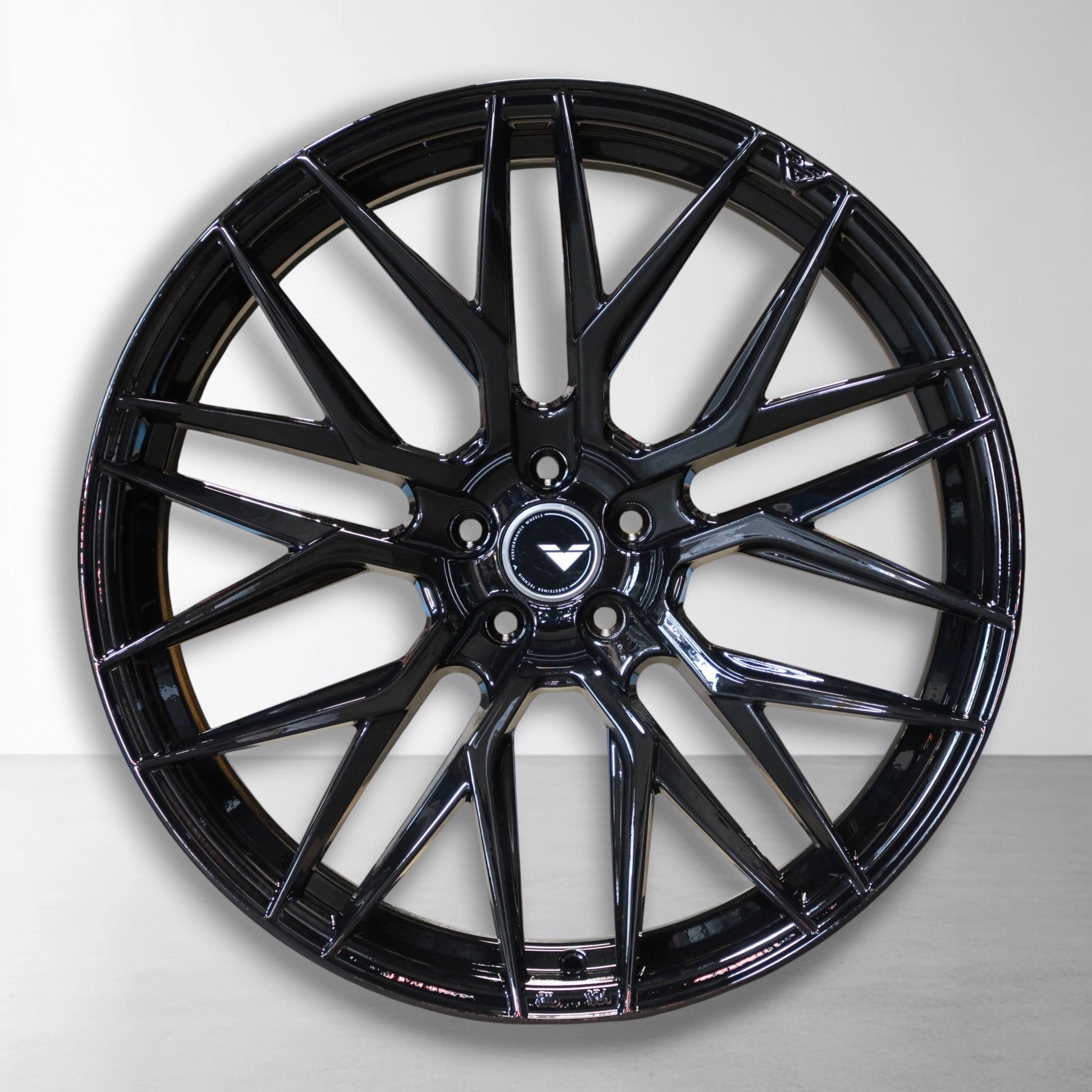 Zwarte 22 inch velg met V-spaken en merklogo in de naafdop