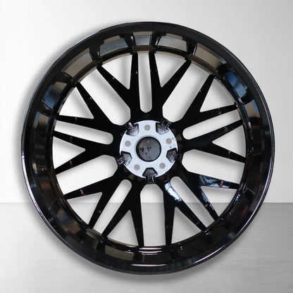 Zwarte 22 inch velg met boutgaten en naafdop, spaken rond