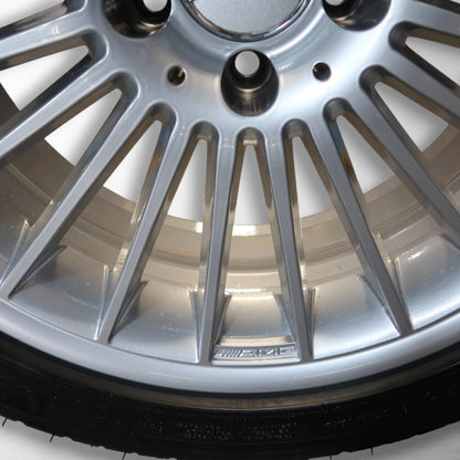 Close-up van zilveren velg met multispaaks en zwarte band