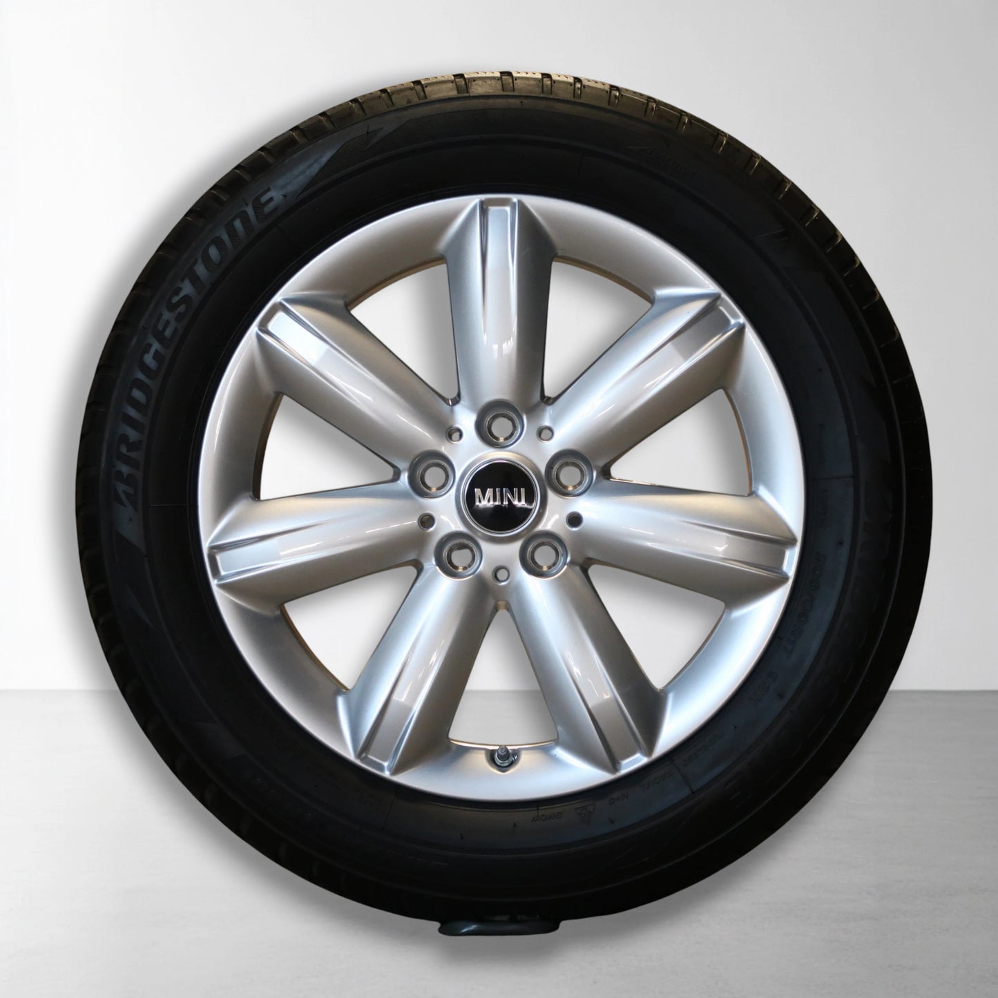 Zilveren 17 inch velg met winterband en MINI-logo in het midden