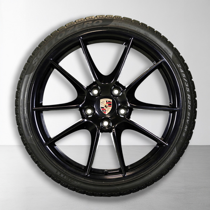 Zwarte velg met Porsche-embleem en winterband, close-up