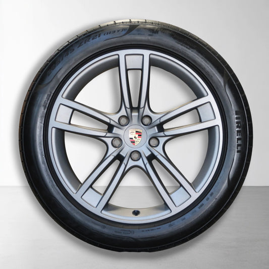 Porsche velg met zomerband; zilveren spaken en naaf in het midden.