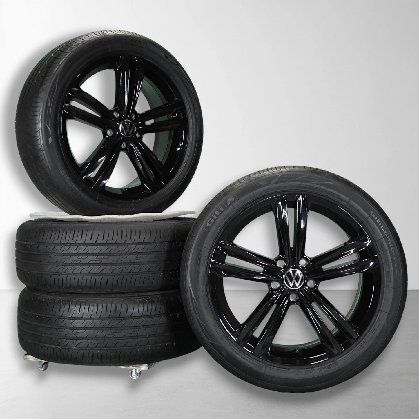 Twee zwarte velgen met zomerbanden, glanzende multi-spokes en Volkswagen-logo