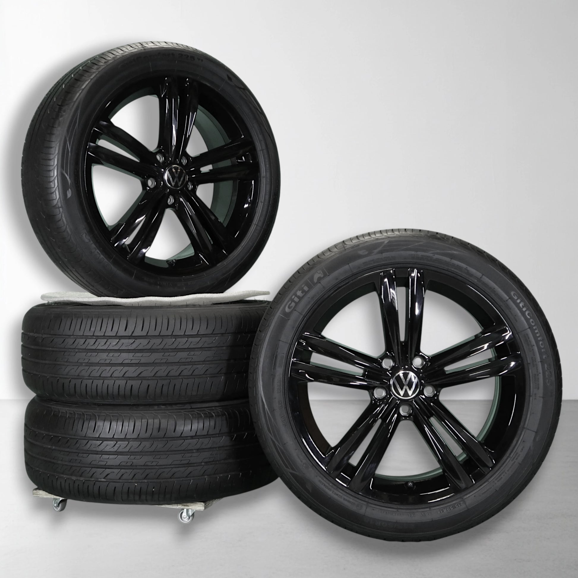 Twee zwarte velgen met zomerbanden, glanzende multi-spokes en Volkswagen-logo