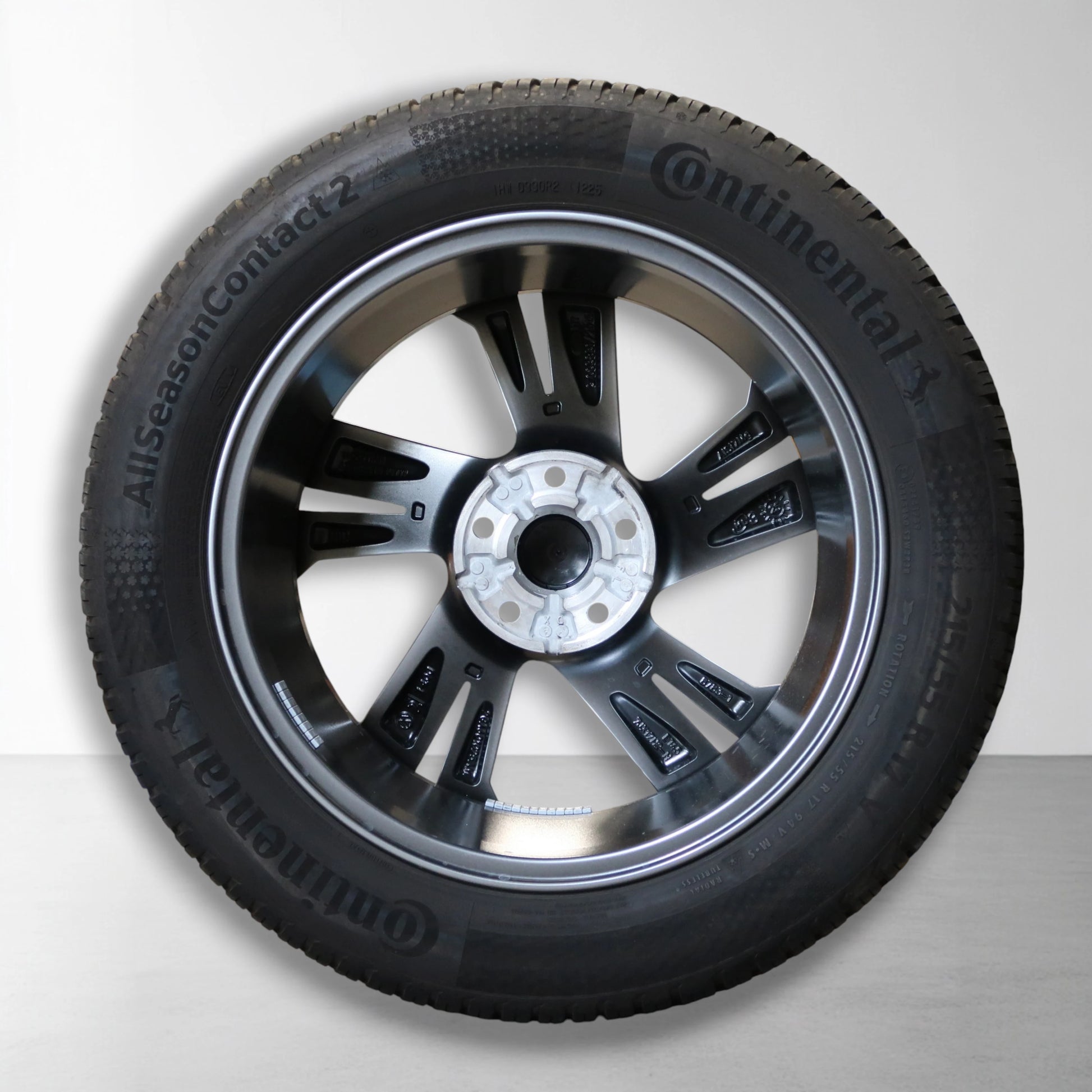 Velg met all-season band; grijs-zilveren spaakdesign en zwarte band rondom.